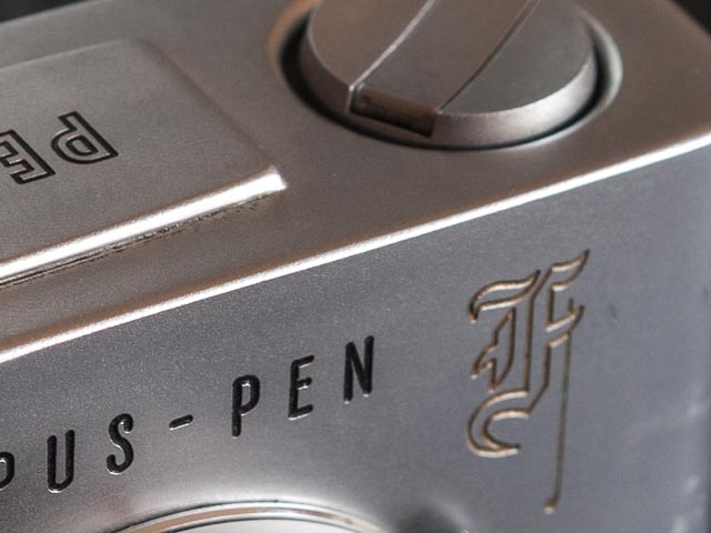 Close up of gothic 'F' logo on Olympus Pen F