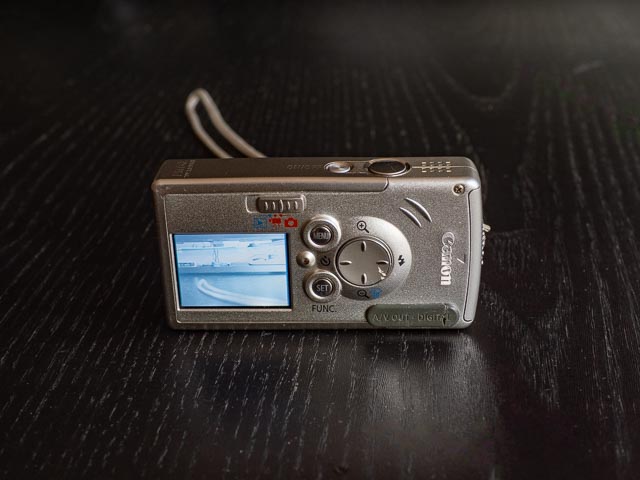 Canon IXUS i in hand to show scal.